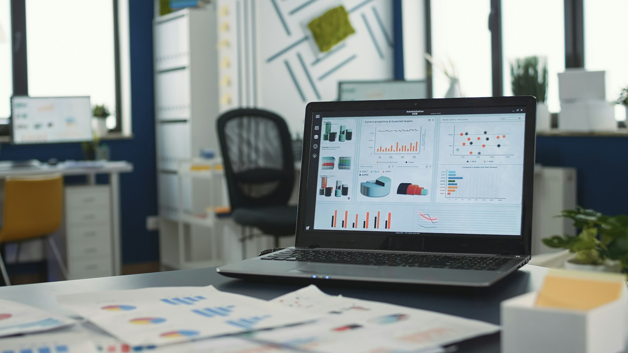 Empty startup office with multiple computer screens displaying financial statistics and closeup on